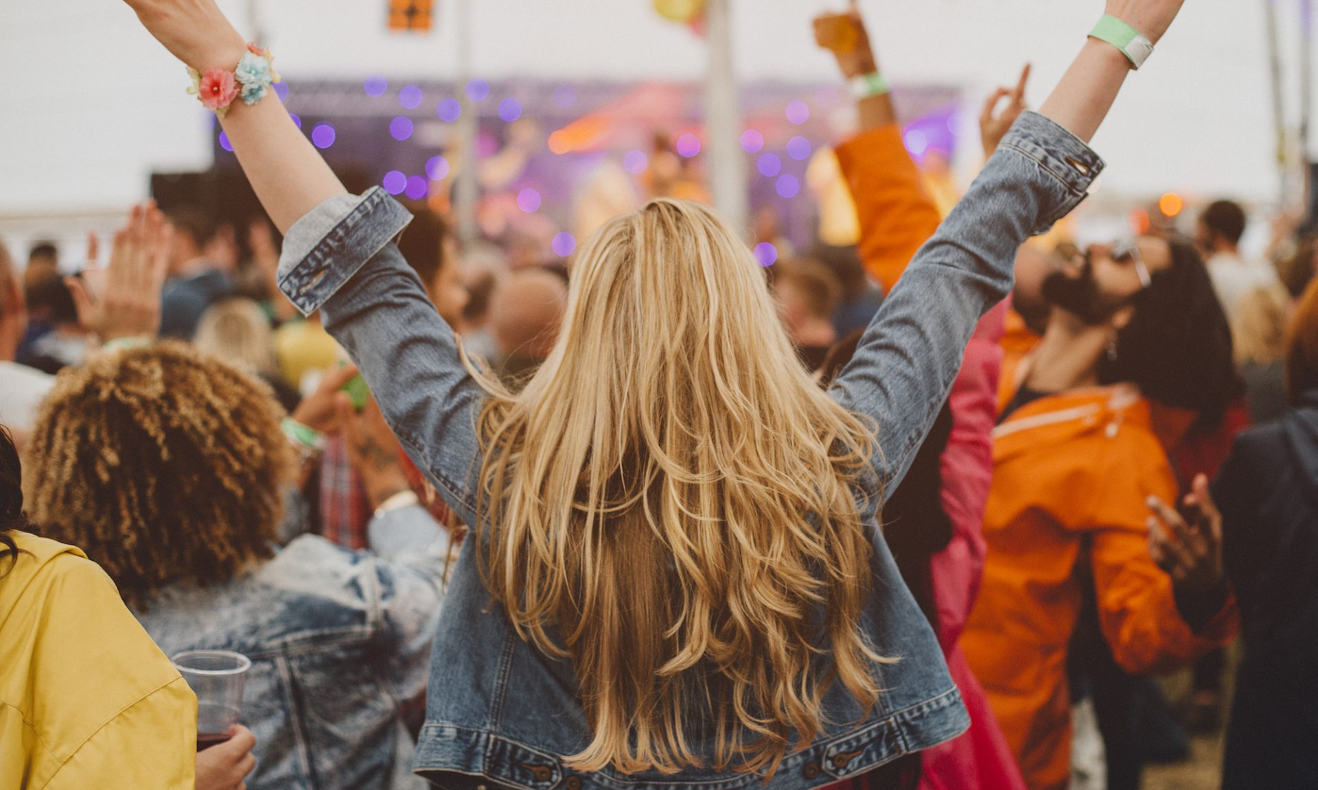 Concert Attendees with Promotional Bracelets (nerdwallet.com)