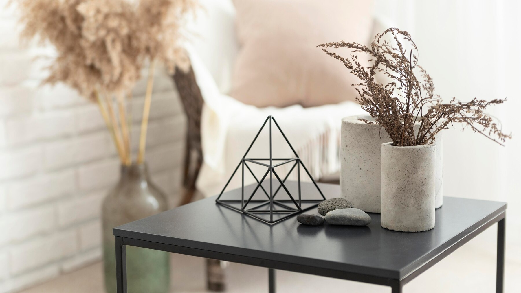 black table with pyramid, stones, and flower on top